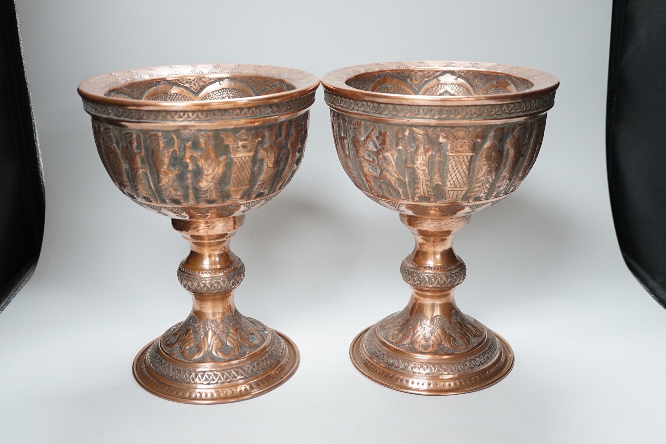 A pair of Persian copper figural decorated chalices, 27cms high